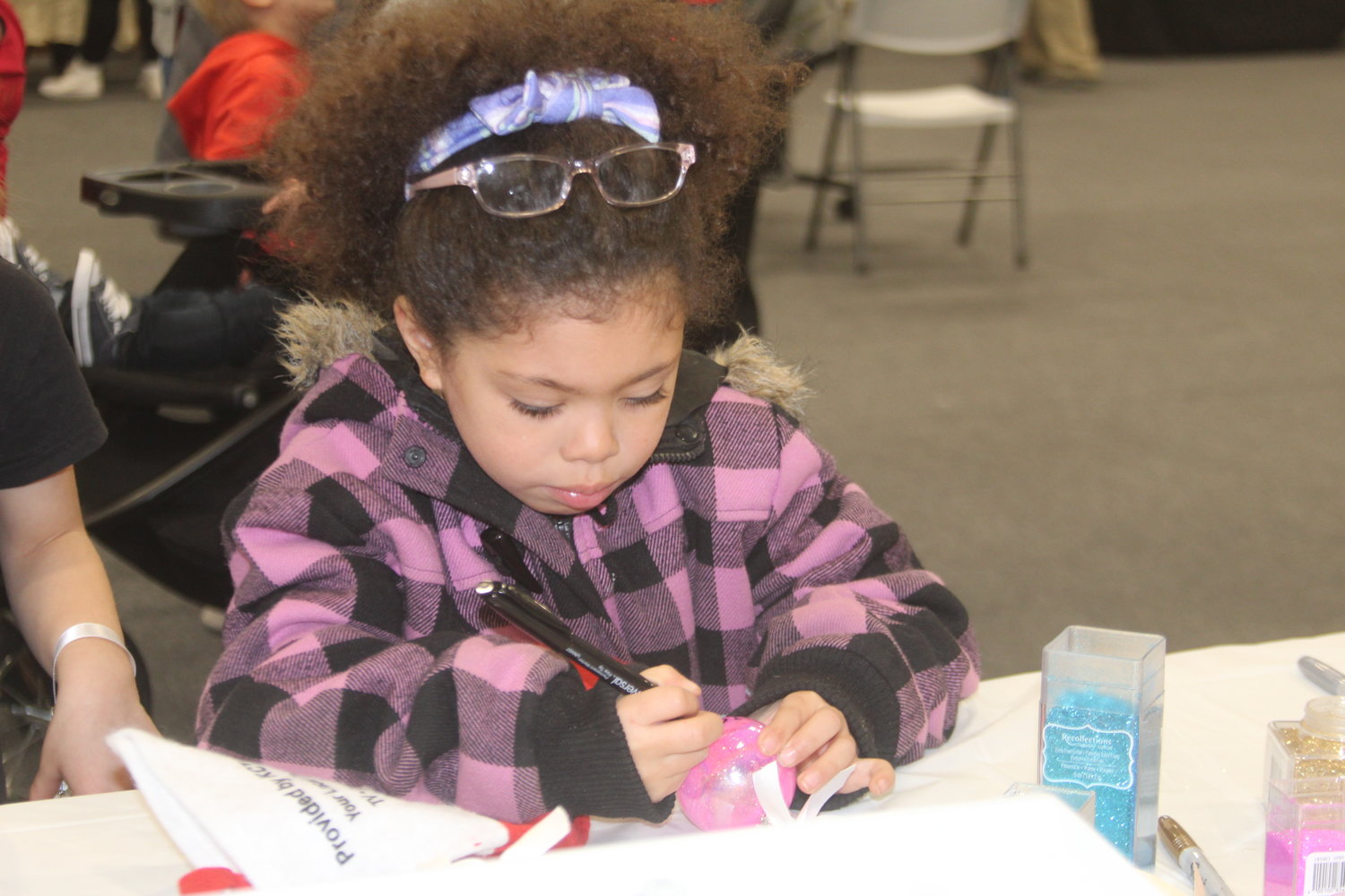 Jaliyah Naler puts the finishing touches on her Christmas ornament.