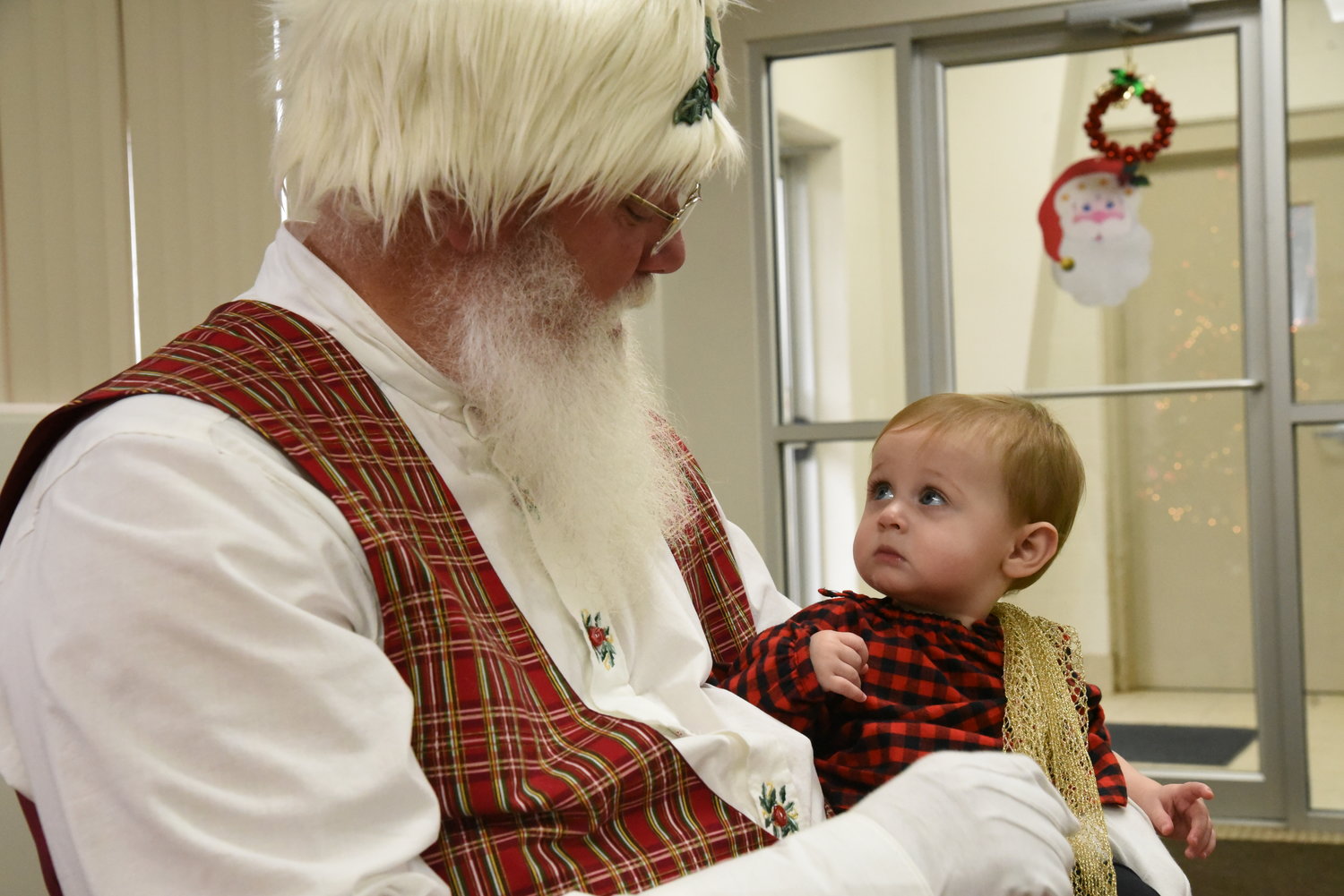 Eleven-month-old Ellie Kiene looks skeptical as she meets Santa at the Riverside fire station on Dec. 14.