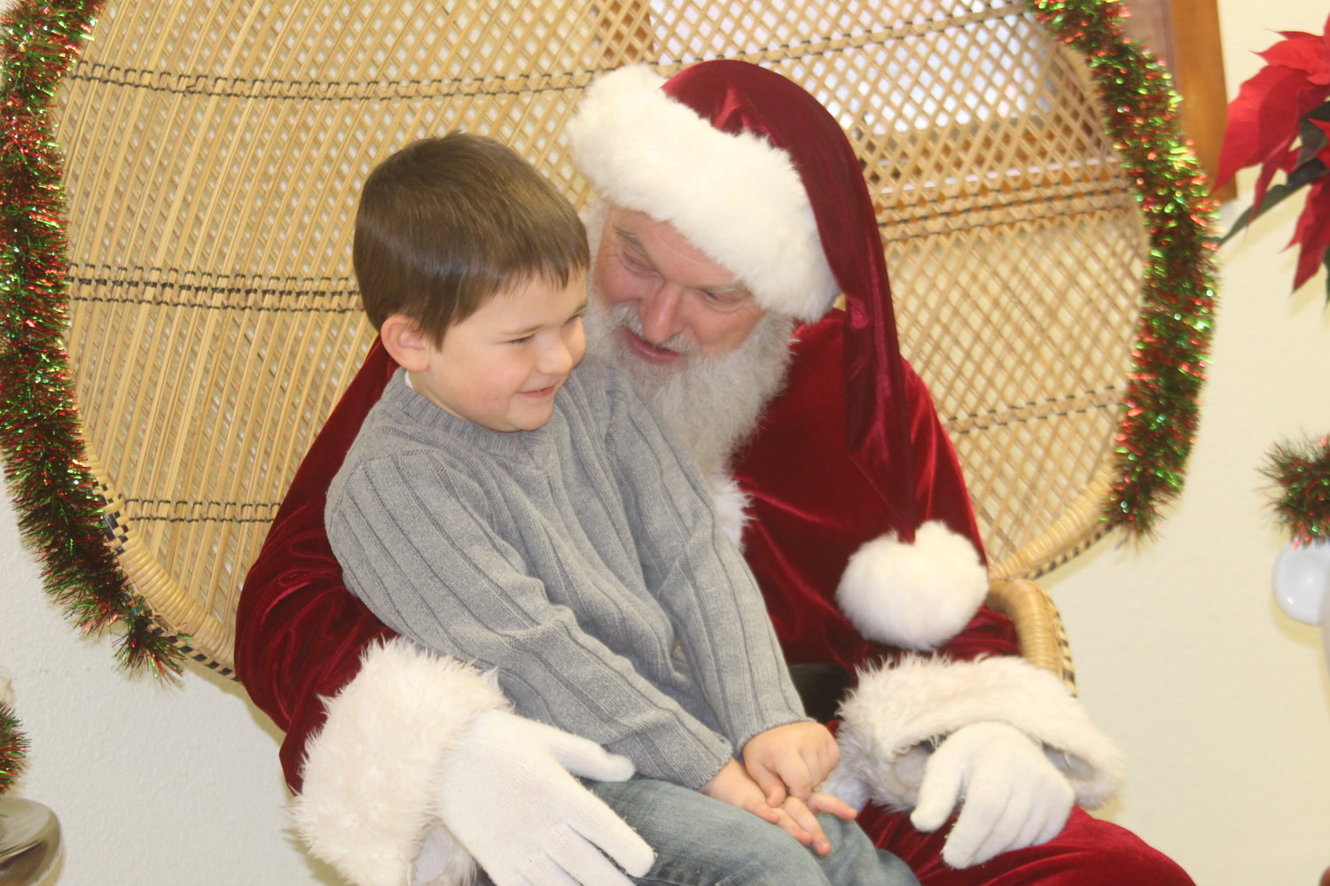 Santa gets a smile out of Brett Miller at the Wellman Library on Saturday, Dec. 14.