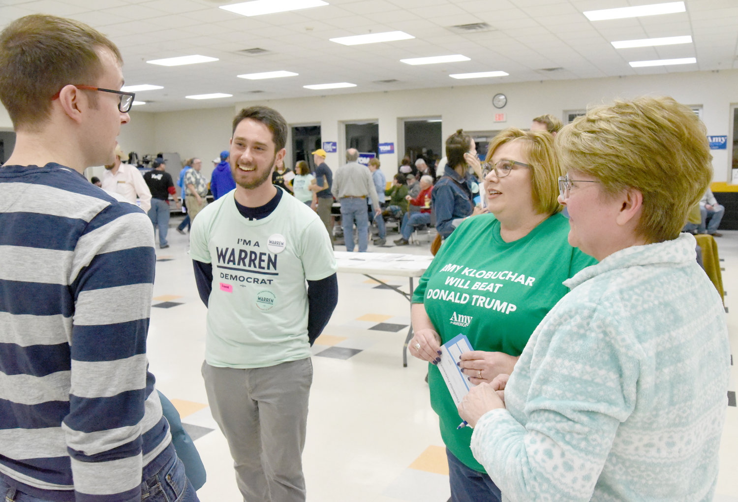 Uncommitted Lone Tree caucus-goer Nick Sterner, left, hears reasons to join the caucus groups for Elizabeth Warren and Amy Klobuchar.