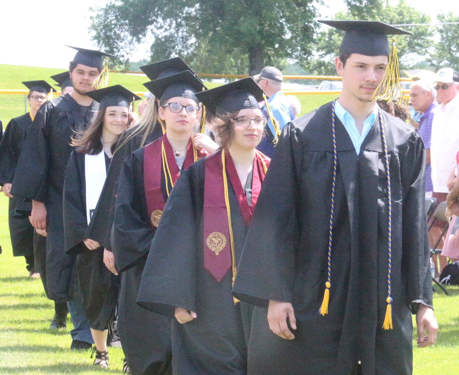 Mid-Prairie High School seniors march onto the football field at the start of Sunday’s commencement.