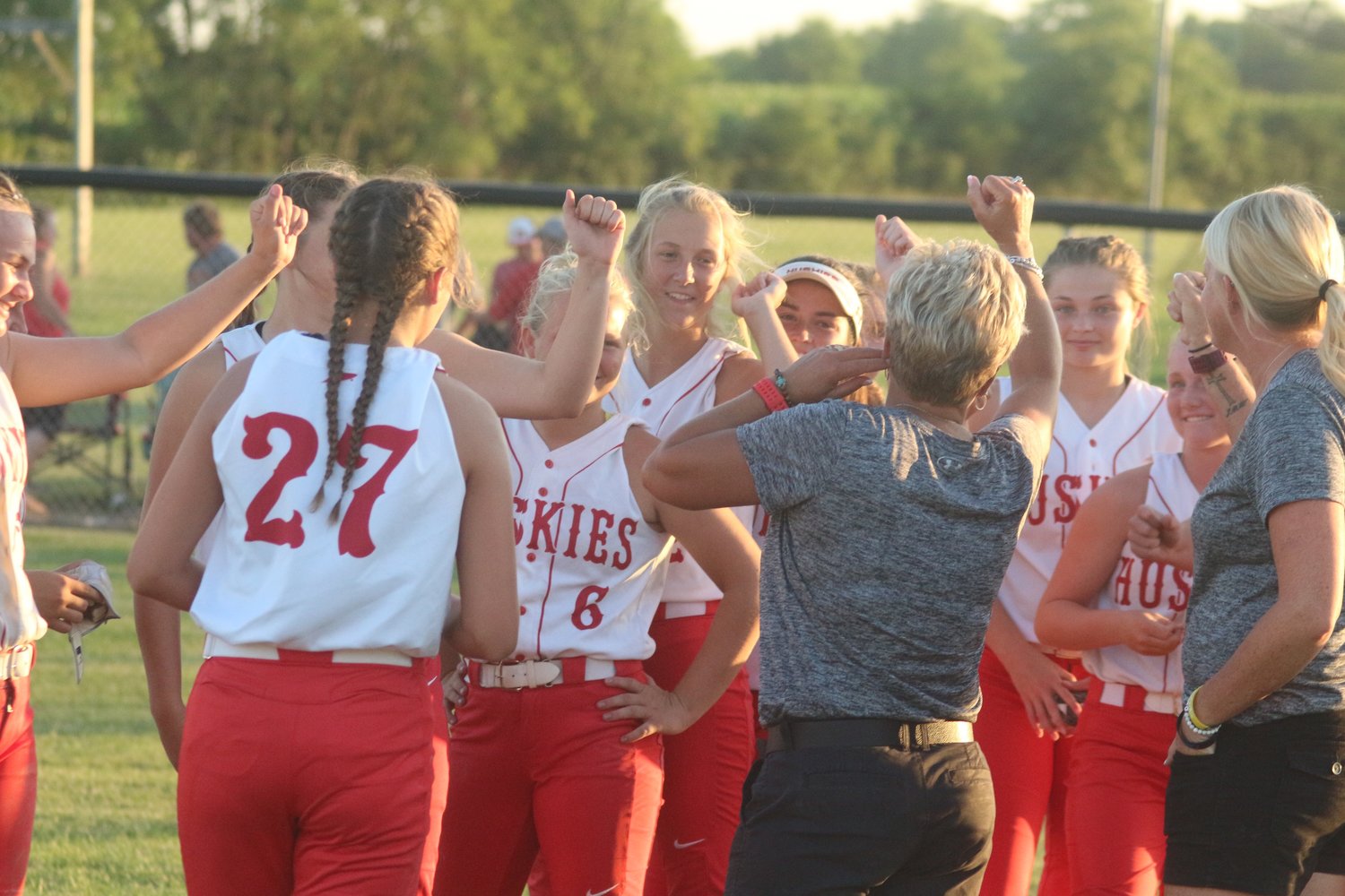 Highland High’s softball players celebrate after Monday night’s tournament victory with coaches Carrie Wieland and Samantha Wieland.