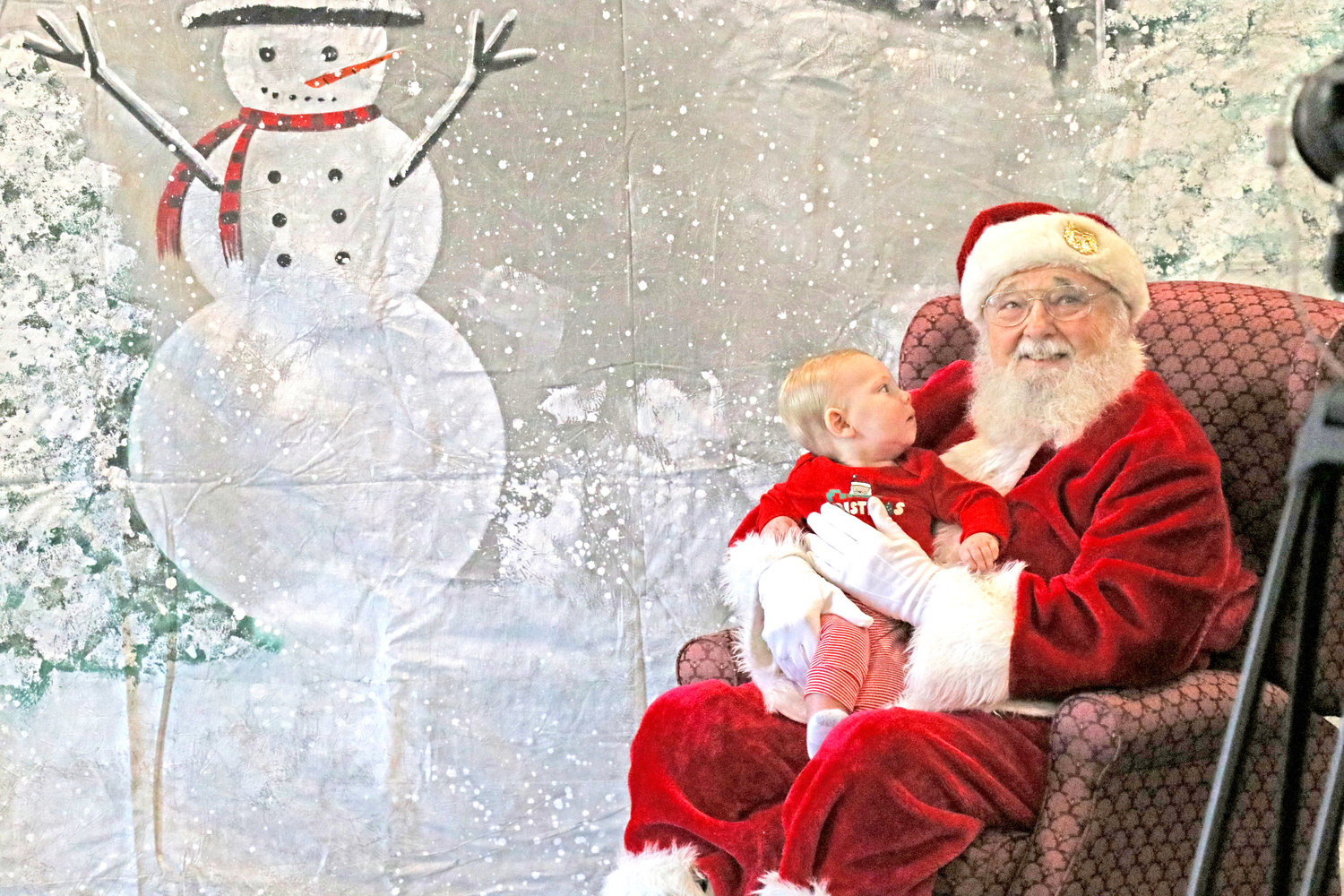 Baby Redlinger, 8 months, was very intrigued by Santa Claus during Christmas in Kalona.
