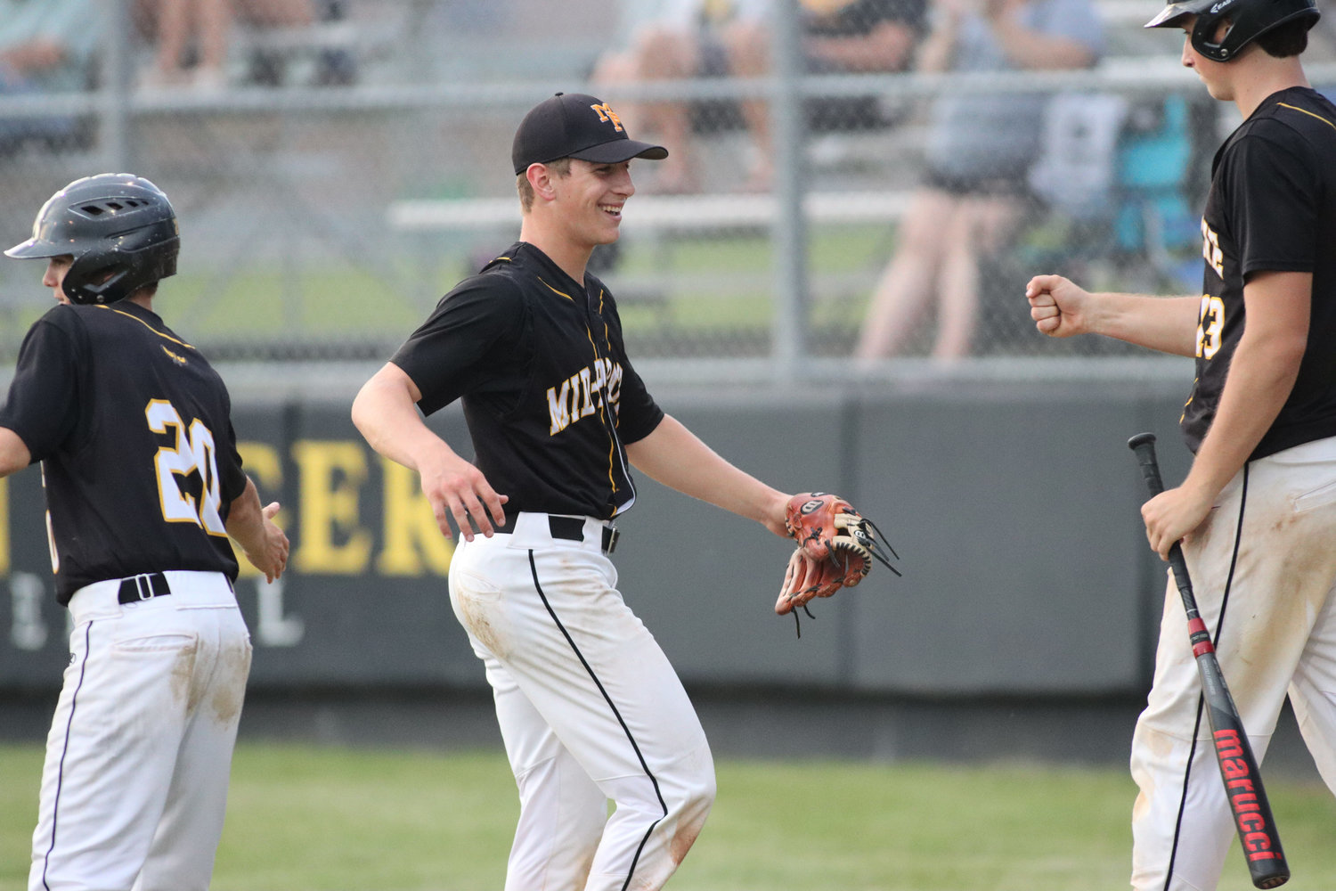 Karson Grout is congratulated by teammates after the final out of an inning during a Mid-Prairie win over Tipton on June 28, 2021.