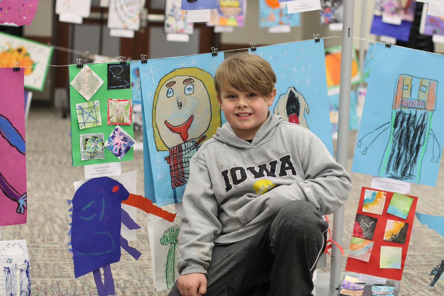 Tucker (second grade) is pictured beside his project at the first annual Mid-Prairie AK-12 art show.