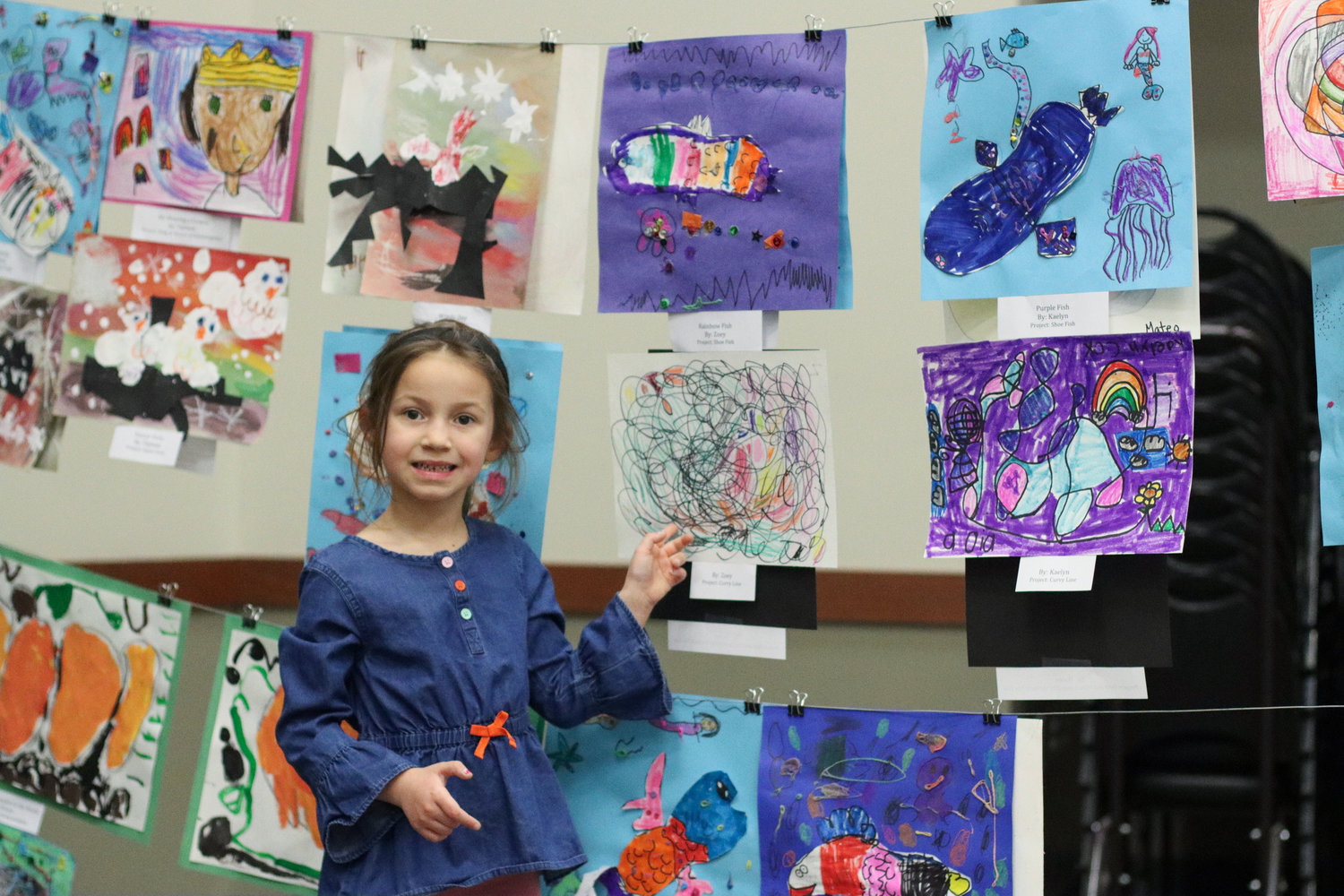 Zoey (kindergarten) points to her project at the first annual Mid-Prairie AK-12 art show.