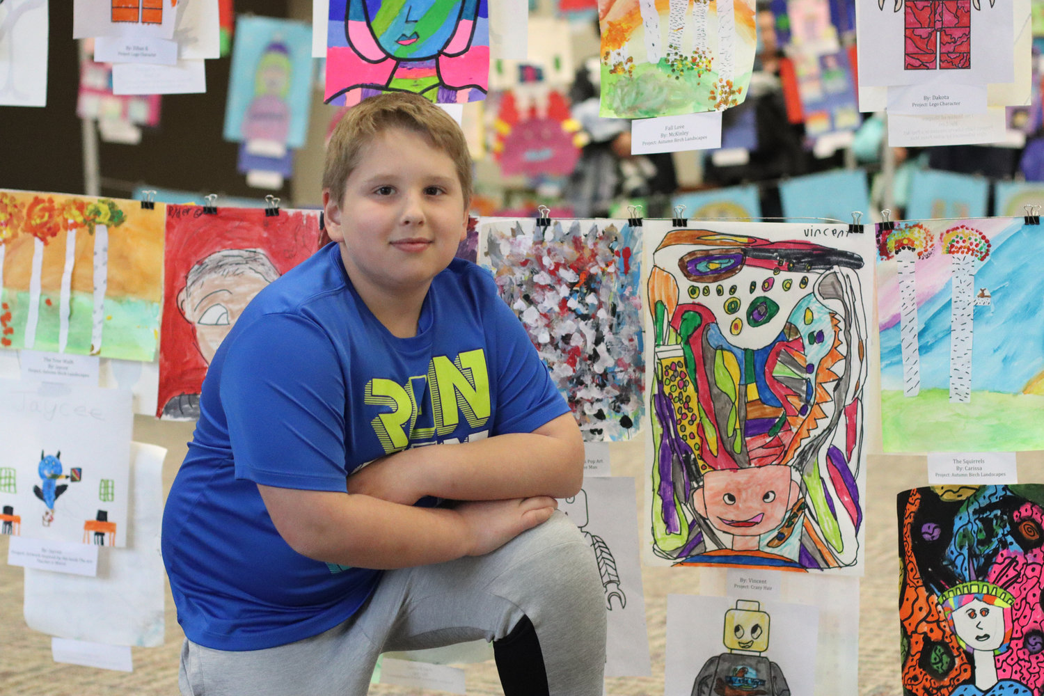 Vince (third grade) is pictured beside his project at the first annual Mid-Prairie AK-12 art show.
