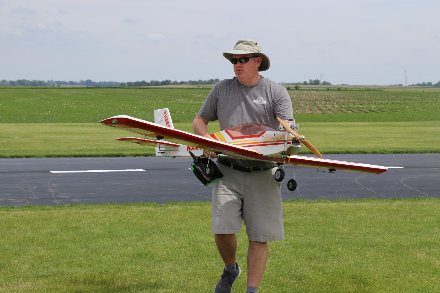 Richard Huyck carries his plane off the airfield after a flight.