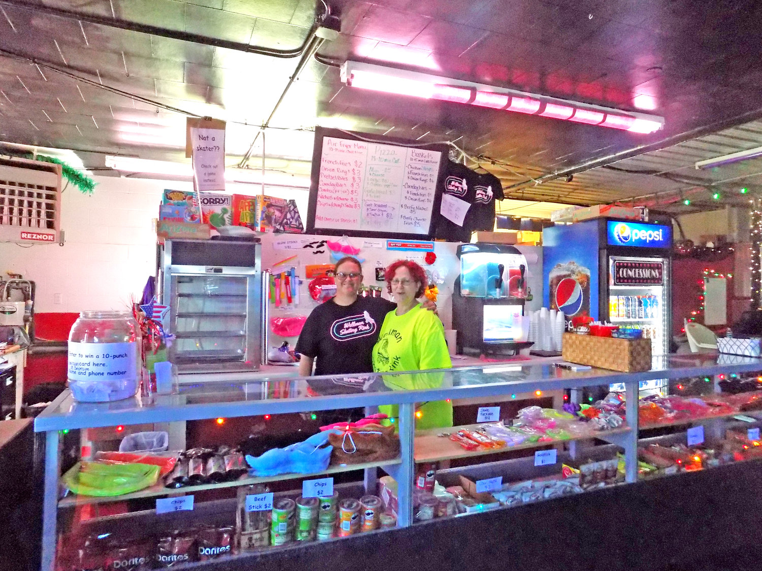 Brenda Reasor and Deb Hill work the concessions bar, where air-fried food and fun accessories can be purchased.