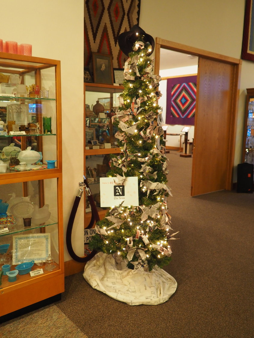 Voters awarded The News’s Christmas tree first place at the Kalona Historical Village.  Origami ornaments made of newsprint were created by Ethan Allen (News Editor Cheryl Allen’s husband) and Jill Kahn (Graphic Designer Anna Kahn’s mom).