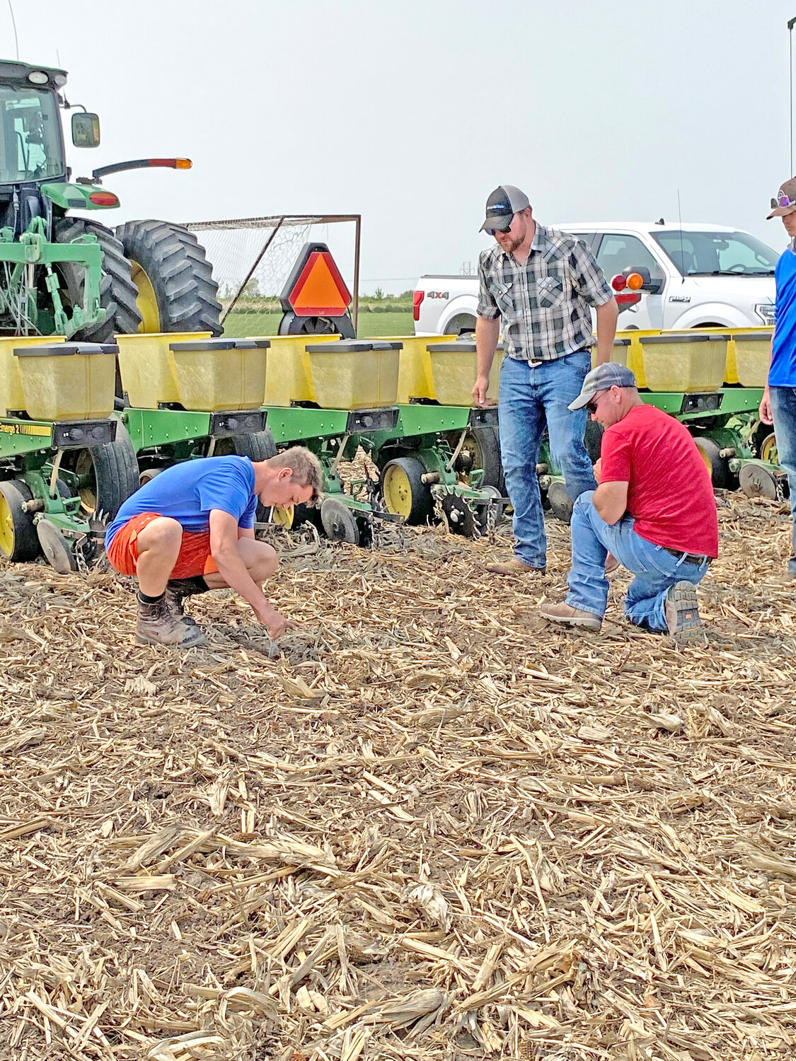Jack Peiffer (junior), Zach Trower (Syngenta), and Brian Chalupa checking seed depth within the first few feet of planting the Highland FFA test plot.